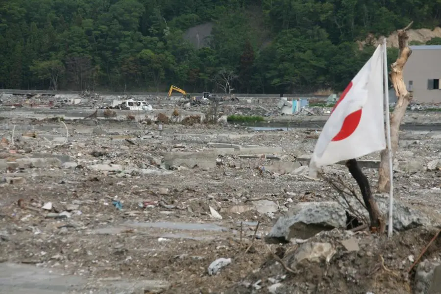 Bandera de Japón en un campo destrozado por el tsunami